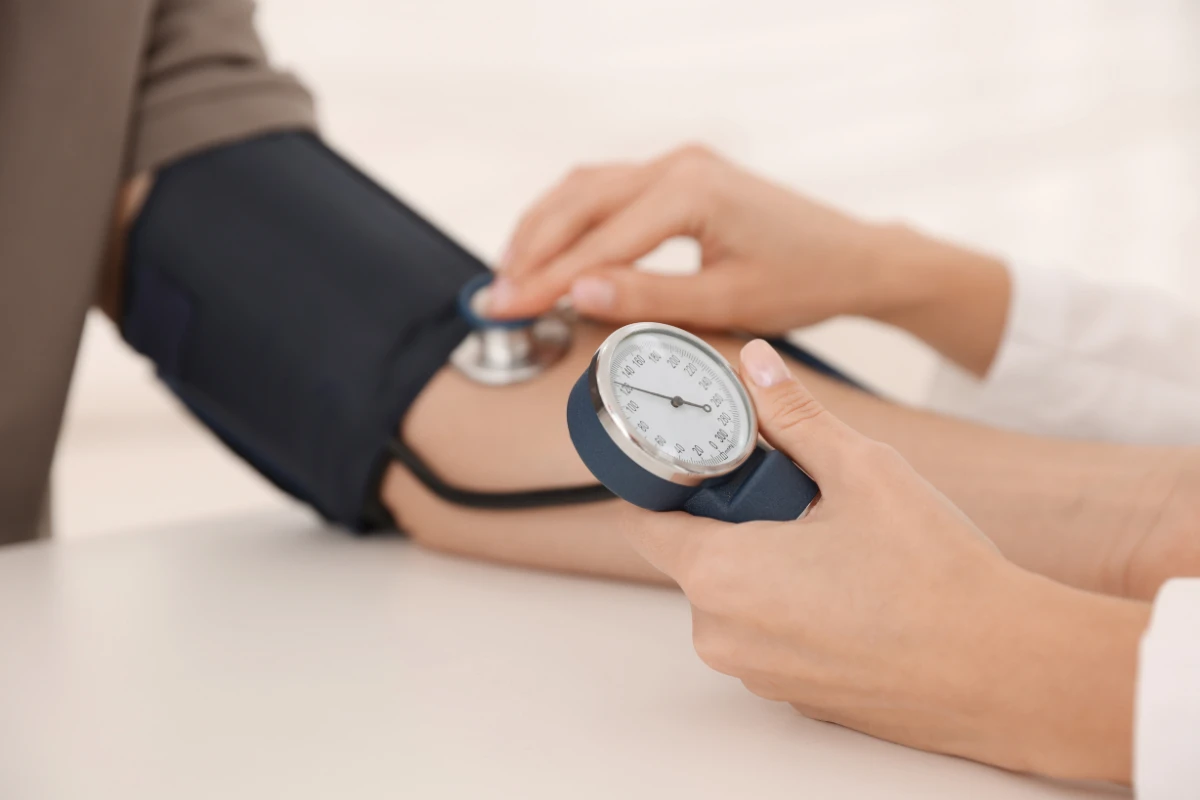 dravotník meria krvný tlak pacientovi ako prevenciu kardiovaskulárnych problémov počas horúčav.